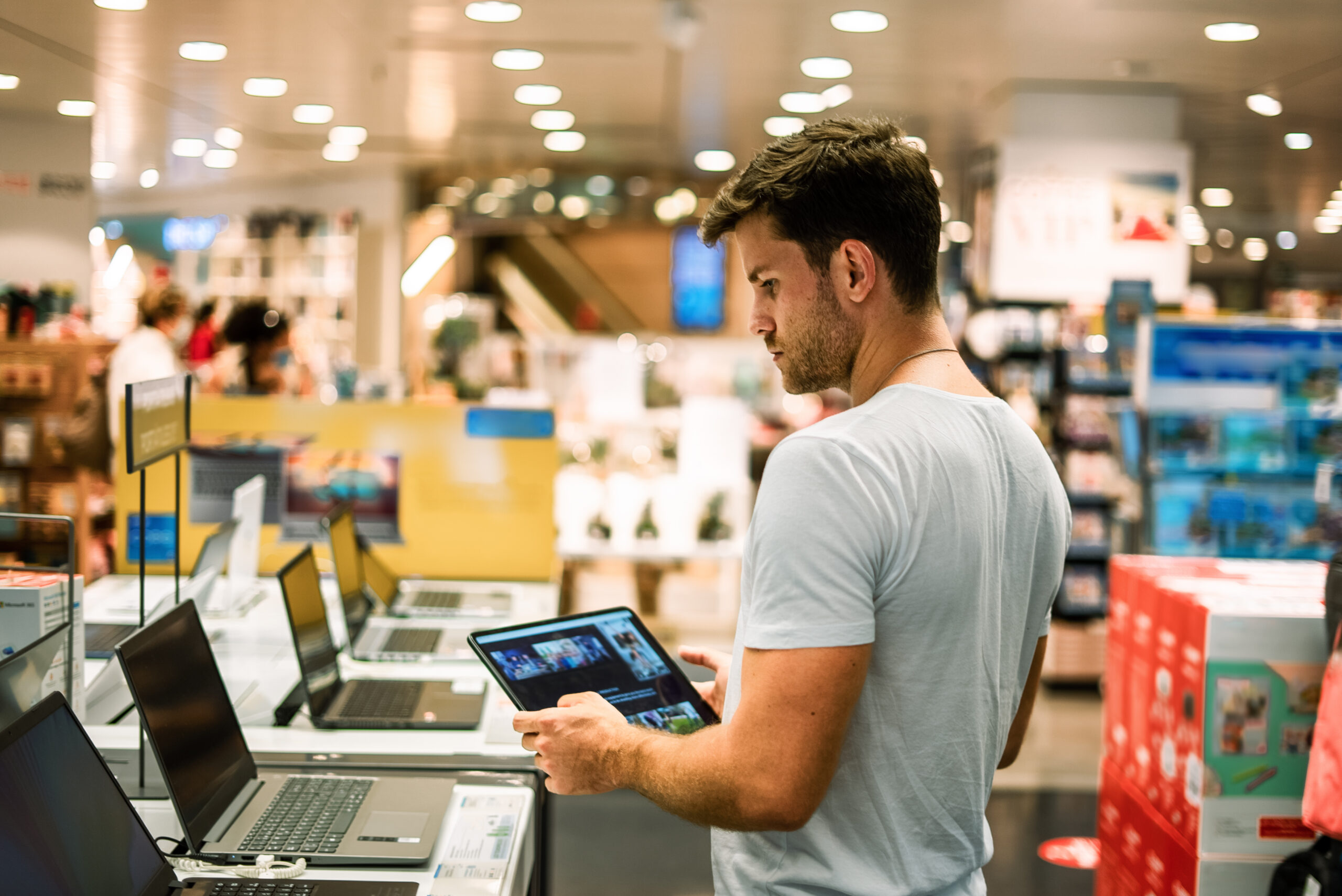 a man holding a tablet in a store. Online store